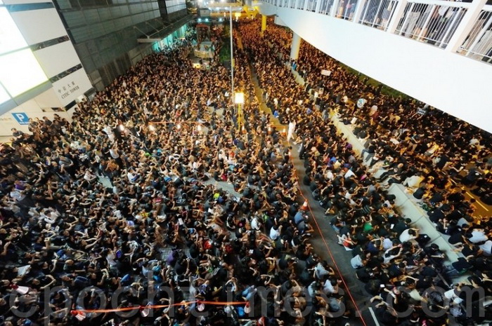 Большая толпа окружила здание правительства Гонконга в пятницу, 7 сентября. Протестующий держит плакат «Отменить». Фото: Сун Сянлун/Великая Эпоха