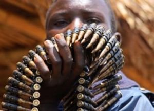 В Демократической Республике Конго юный участник народного ополчения несет боеприпасы в центр разоружения ООН. Фото: Stuart Price/AFP/Getty Images