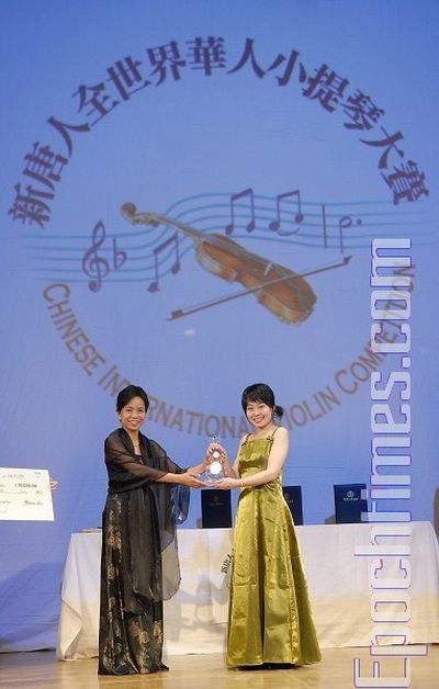 Председатель жюри конкурса Линь Цзя вручает приз за 1-е место конкурсантке № 17 Тун Янь. Фото: Даи Бин/ The Epoch Times