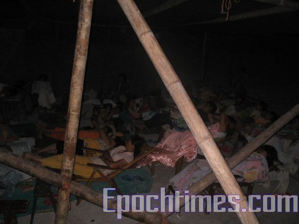 Крестьяне ночью спят в самодельных навесах возле строящейся пристани. Фото: The Epoch Times