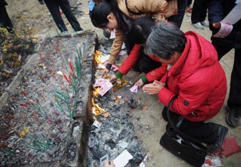 Жители пострадавших от землетрясения районов поминают своих погибших родных.   Провинция Сычуань. 25 января 2009 г. Фото: China Photos/Getty Images