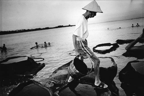 Рабочий, занимающийся выпариванием соли. Залив Янбу провинции Хайнань. 2003 год. Фото: Wan Jingchun