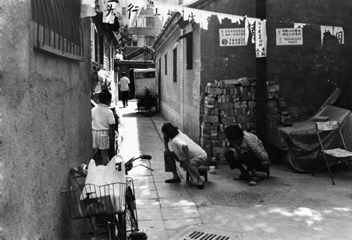 Женщины пристально следят за незнакомцем, приехавшим в их район. Город Пекин. 1999 год. Фото: Wu Qiang
