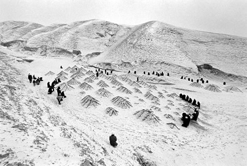 Люди пришли на кладбище, занесенное снегом, поклониться умершим родным. Провинция Нинся. 1998 год. Фото: Wan Zheng