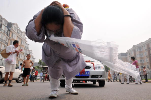 Китаянка Чжан Тинтин протянула на своей косе 6 автомобилей. Фото: AFP/Getty Images 