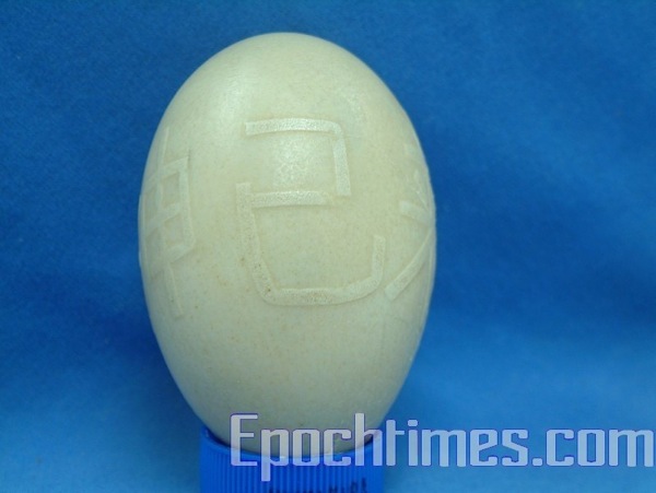 Гусиное яйцо, на скорлупе которого написано китайскими иероглифами «Бог уже пришёл», а   также иероглиф «царь». Фото: The Epoch Times