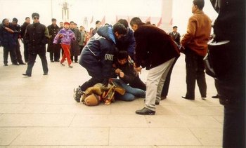 Сотрудники китайских служб безопасности арестовывают последовательницу Фалуньгун. Фото с epochtimes.com