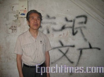 Сунь Вэньгуан у стены своего дома с ругательными в его адрес надписями. Фото: The Epoch Times