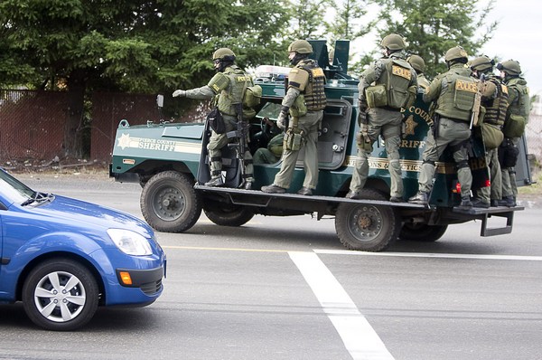 Участники команды ОМОН едут на бронированной машине, ища подозреваемого. Фото: Stephen Brashear/Getty Images