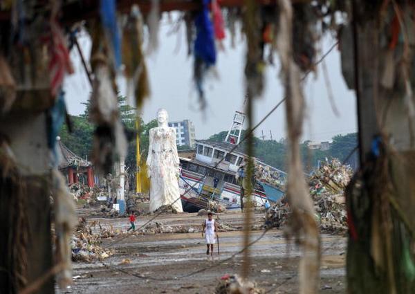 Строения вдоль реки Марикина и большая статуя после урагана Кетсан в Маниле  (29.09.2009). Фото: TED ALJIBE/AFP/Getty Images