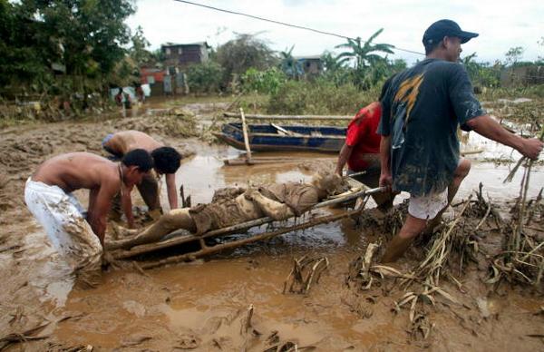 Жители перевозят потерпевшего от урагана  в городе Кьезон в Маниле (27.09.2009). Фото:  STR/AFP/Getty Images