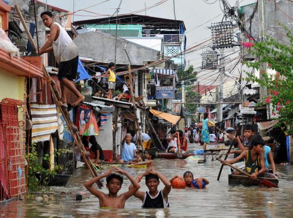 Последствия урагана Кетсан в городе Бинан в Маниле  (30.09.2009). Фото: TED ALJIBE/AFP/Getty Images