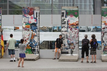 Люди смотрят на мемориал из остатков берлинской стены. Фото: Sean Gallup/Getty Images