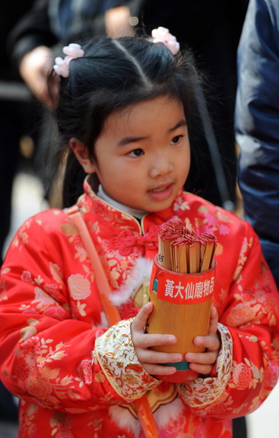 3 февраля 2011 года.  Гонконг, В первый день Нового года, маленькая девочка держит палочки с предсказаниями. Фото: Mike Clarke/AFP/Getty Images