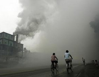 Профессиональный риск: велосипедисты едут сквозь туман загрязненного воздуха, произведенного заводом в Юйтяне, в 62-х километрах восточней Пекина, в провинции Хэбэй. В прилегающем районе большая смертность от заболеваний раком, а жители деревень, ищущие правды преследуются. Фото: Peter Parks/AFP/Getty Images