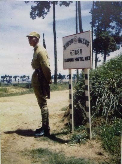Солдат охраняет вход на территорию общежития американских военных в городе Куньмин