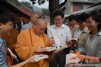 Ши Юнсин, настоятель монастыря Шаолинь, оставляет автографы туристам на память. Фото с сайта epochtimes.com