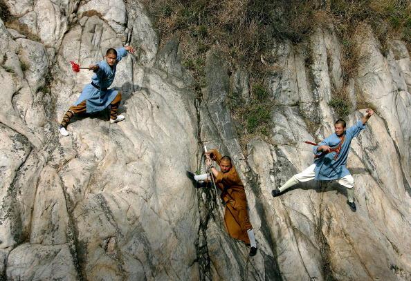 Шаолиньские монахи демонстрируют своё мастерство ушу в горах Суншань недалеко от монастыря Шаолинь. Фото: Cancan Chu/Getty Images
