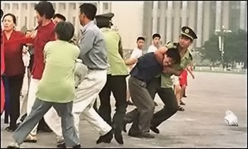 Китайские полицейские хватают последователей Фалуньгун, распространяющих на улице листовки. Фото с epochtimes.com