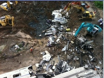 Экскаваторы в срочном порядке закопали упавшие с моста вагоны. Фото с epochtimes.com