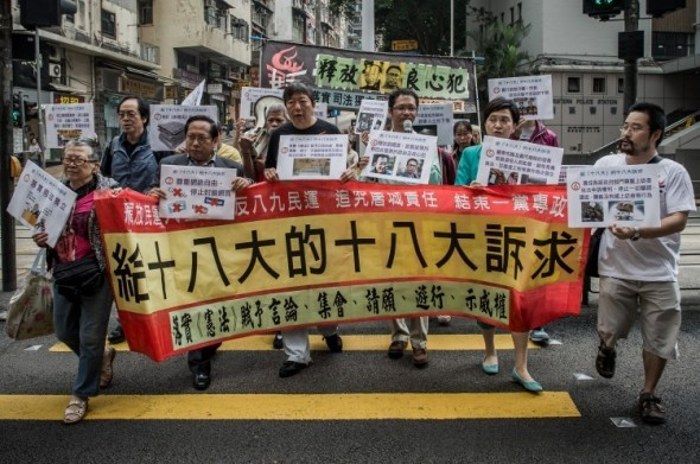 Продемократический законодатель Ли Чок-ян (3-й слева) и другие демонстранты держат плакаты, направляясь к китайскому департаменту по связям, во время акции протеста против центрального правительства в Пекине, Гонконг, 8 ноября 2012 года. Фото: Phillipe Lopez/AFP/Getty Image