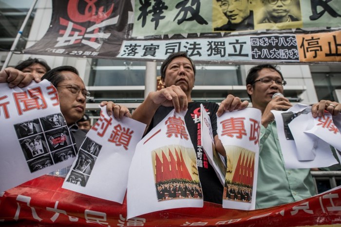 Продемократический законодатель Ли Чок-ян (посередине) разрывает фото, на котором изображены китайские лидеры на съезде, в знак протеста против политики центрального правительства КНР, Гонконг, 8 ноября 2012 года. Фото: Phillipe Lopez/AFP/Getty Image