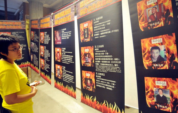 Женщина рассматривает выставку с фотографиями жертв самосожжения в Тибете. Более 50 человек совершили акт самосожжения в тибетских населённых пунктах Китая с февраля 2009 года. Фото: Mandy Cheng / AFP / GettyImages