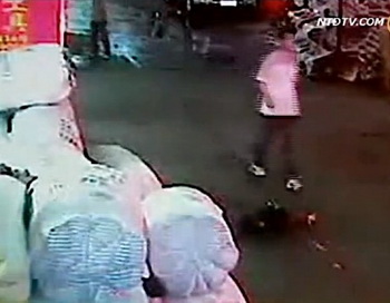Человек проходит мимо Юэюэ через несколько секунд после того, как она попала под машину. Фото: Screenshot NTDTV