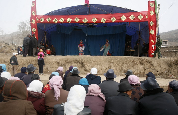 Жители деревни Ланьлункоу смотрят оперу «Циньцян» на храмовой ярмарке, состоявшейся  в честь празднования фестиваля «эр юэ эр» или «Дракон поднимает голову». Фото: China Photos/Getty Images