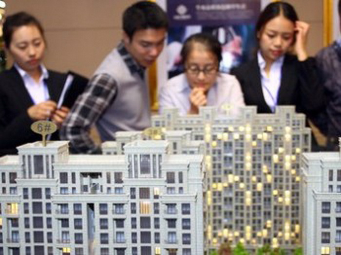 Потенциальные покупатели разглядывают модель роскошного жилого района. Фото: AFP/Getty Images