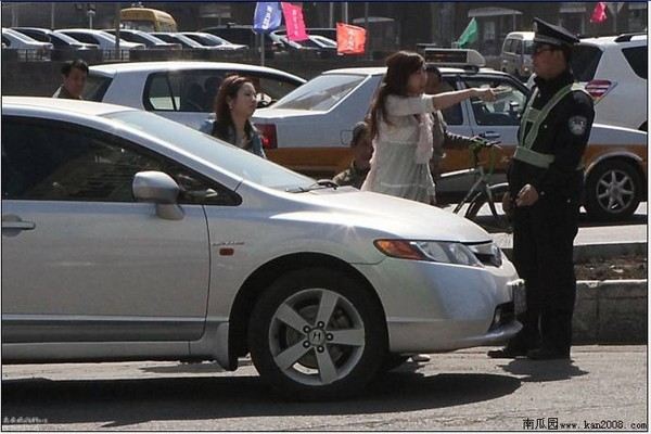 Женщина, ехавшая без прав, угрожает остановившему её дорожному полицейскому. Провинция Цзилинь. Апрель 2011 год. Фото с kanzhongguo.com
