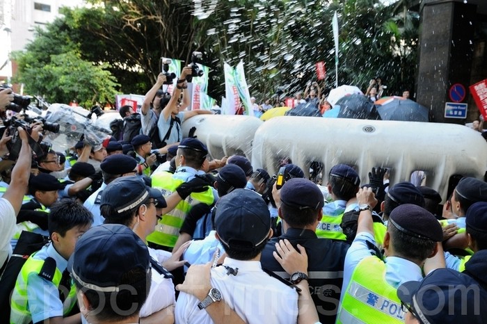 Полицейские усмиряют демонстрантов перцовой водой. Гонконг. Июнь 2012 год. Фото: The Epoch Times