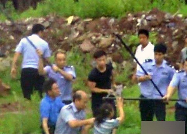 Полицейские бьют палками рабочую кирпичного завода. Провинция Хунань 2011 год. Фото с kanzhongguo.com