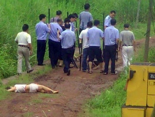 Избитая полицейскими женщина осталась лежать на дороге. Провинция Хунань 2011 год. Фото с kanzhongguo.com
