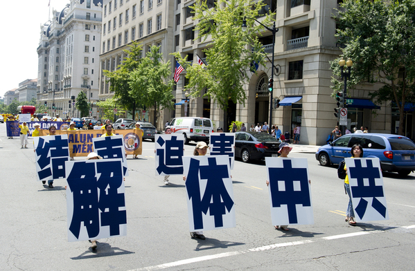 Участники шествия несут иероглифы, означающие «Распад компартии Китая». Фото: The Epoch Times