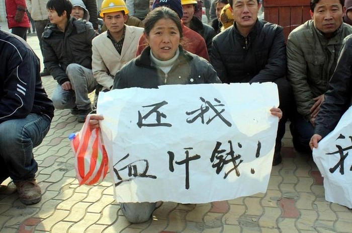 Рабочие на коленях просят выплатить им долг по зарплате. Провинция Шэньси. Январь 2013 года. Фото с epochtimes.com