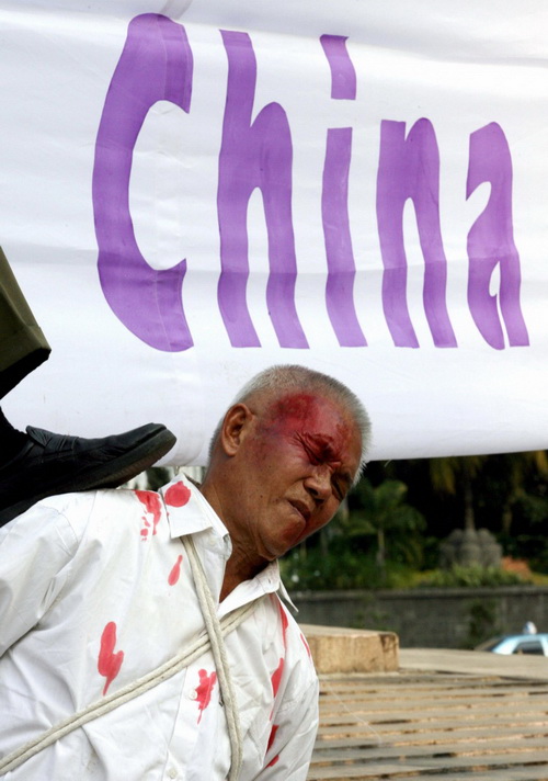 Последователи Фалуньгун из Индонезии демонстрируют сцены жестоких пыток заключённых китайской полицией во время акции протеста в Джакарте 7 октября 2006 года. Фото: Adek Berry/AFP/Getty Images
