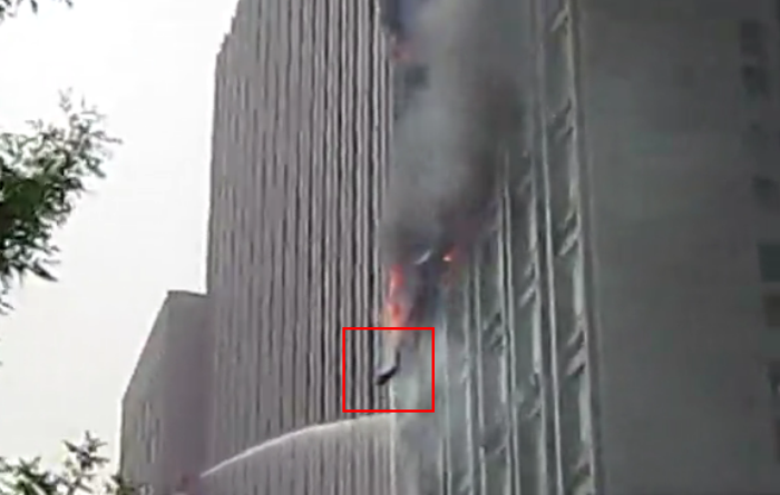 Пожар офисного здания в Тяньцзине 4 марта, кадр из видео. Видно, как в чёрном дыму из окна кто-то выпрыгнул.  Фото с epochtimes.com