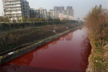 В Китае продолжает ухудшаться экология. Вода в реке Цзяньхэ в провинции Хэнань покраснела от выбросов местных заводов. Фото: AFP/Getty Images