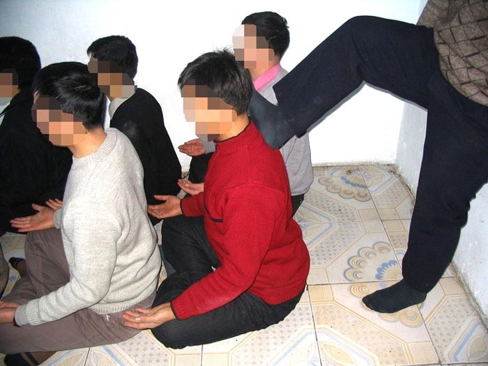 Инсценировка пытки «сидение на твёрдом полу». Фото: minghui.org