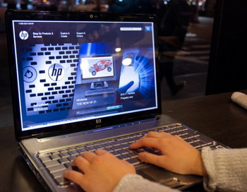 Человек просматривает веб-сайт Hewlett Packard, используя компьютер HP в кафе Мидтаун в Манхэттене 23 февраля. Фото: Benjamin Chasteen/The Epoch Times