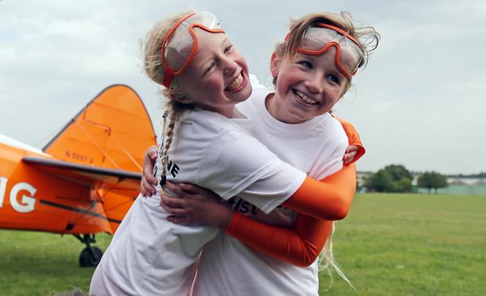 Две 9-летние девочки совершили полёт, стоя на крыльях бипланов