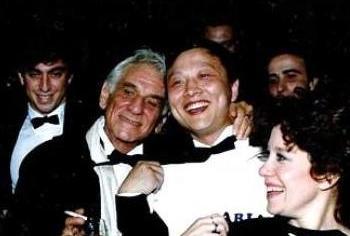 Брайт Шэн с Ленардом Бернстайном (С) и исполнителями в 1988г. после премьеры «Арий и Баркарол», музыки, сочиненной Леонардом Бернстайном и оркестрованной Брайтом Шэном. (Фото предоставлено мистером Шеном)