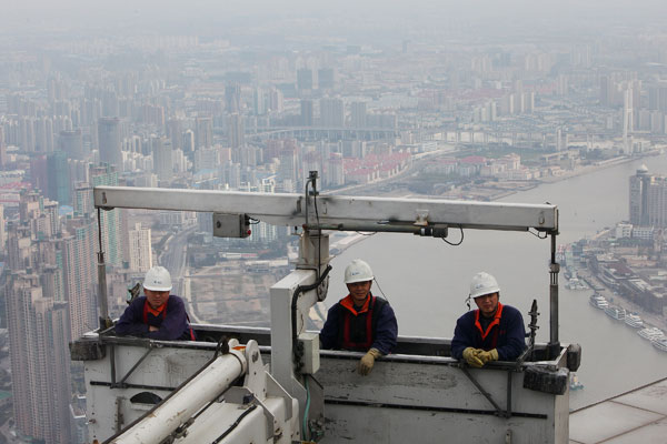 Expo 2010.  Мойщики окон в подвесных люльках на высоте 492 м на здании Финансового центра в Шанхае. Фото: Feng Li/Getty Images