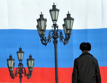 Человек перед большим русским флагом в Москве. Фото: SERGEI SUPINSKY/AFP/Getty Images
