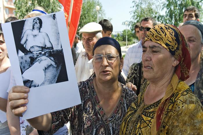 Чеченская женщина держит фотографию родственника, убитого российским офицером во время протестного митинга в Грозном 28 июня 2007 года. Фото: RUSLAN ALKHANOV/AFP/Getty Images