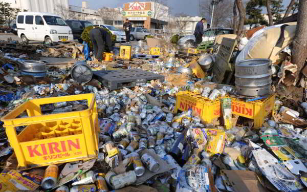 Япония после цунами пытается справиться с разрушениями. Фото: NICHOLAS KAMM/YOMIURI SHIMBUN/MIKE CLARKE/TORU YAMANAKA/AFP/Getty Images