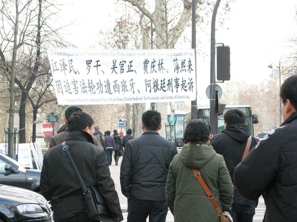 Группа китайских туристов остановилась возле баннера, обсуждая увиденное. Фото: Hao Yang/The Epoch Times