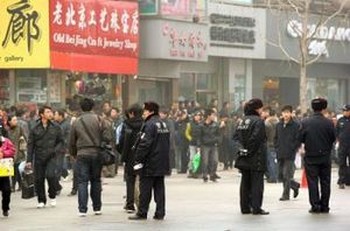 Полиция патрулирует торговую улицу Ваньфуцзин в Пекине, на которой 20 февраля 2011 года собрались манифестанты. Распространенные по Интернету сообщения призвали недовольных китайцев собраться в 13 крупных городах Китая в людных местах по образцу «Жасминовой революции», охватившей Ближний Восток. Фото: Peter Parks /AFP /Getty Images