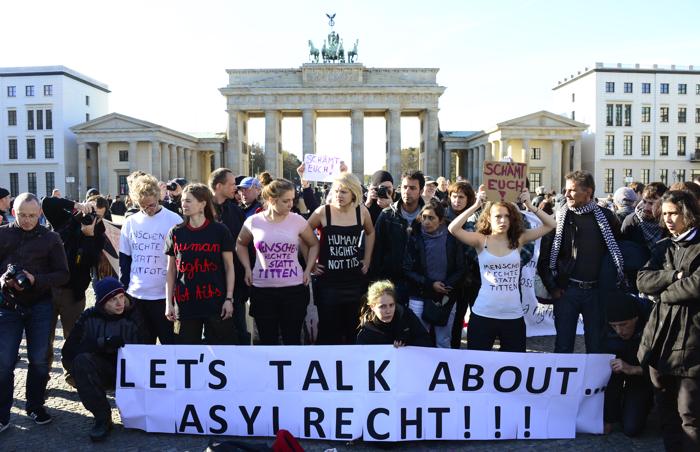 Беженцы протестуют перед Бранденбургскими воротами в Берлине